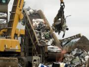 Scrap metal is loaded onto a conveyor belt and into a massive shredder at Pacific Coast Shredding.