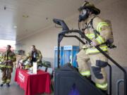 Photos by Vivian Johnson/ for The Columbian
Scott Squires, who fought and beat lymphoma in the past decade, rides a StairMaster outside the Hazel Dell Fred Meyer to raise money and awareness for the Lymphoma &amp; Leukemia Society.  Squires and other firefighters will participate in an annual stair-climb fundraiser in Seattle, as well.