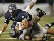 Kieran McDonagh, 2, of Skyview High School loses the football temporarily as he is tackled by Joe Beattie, 67, of Skyline High School during the Class 4A state championship football game December 3, 2011 at the Tacoma Dome in Tacoma, Washington.