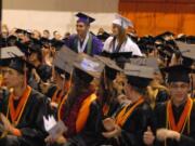 Battle Ground: Anna Downs, in white, and Kevin Stamper, in purple, sit among seniors from Battle Ground High School at the school's graduation ceremony June 18.