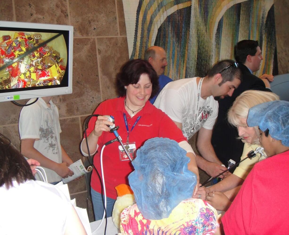 Salmon Creek: Jenipher Storms, center, a certified surgical technologist at Legacy Salmon Creek Medical Center, helps children &quot;operate&quot; on a stuffed animal -- Suzi Surgi-Duck -- during the recent fifth annual Healthy Kids Fair at Legacy Salmon Creek.