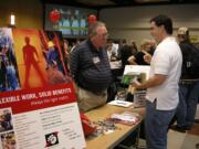 A job seeker inquires about potential openings at a Clark College job fair earlier this year.