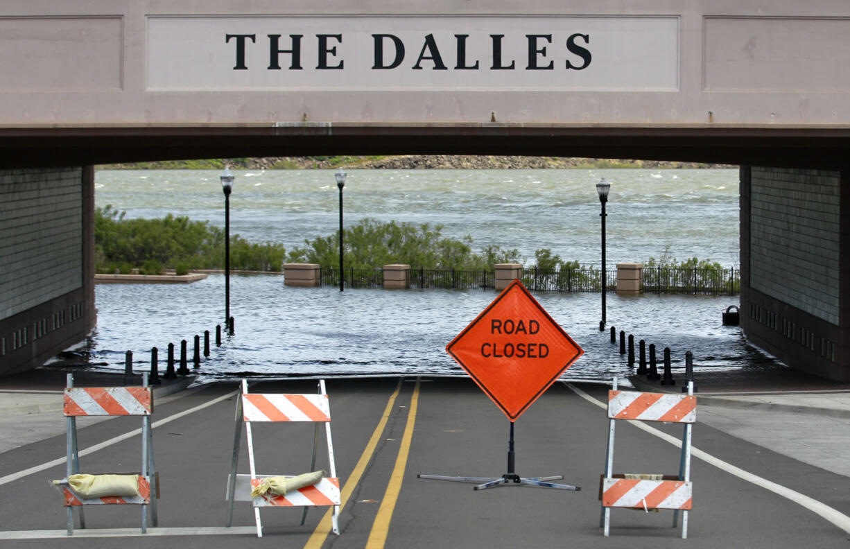 The Columbia River washes over a street Thursday in The Dalles, Ore. States across the West are bracing for major flooding in the coming weeks once a record mountain snowpack starts melting and sending water gushing into rivers, streams and low-lying communities.