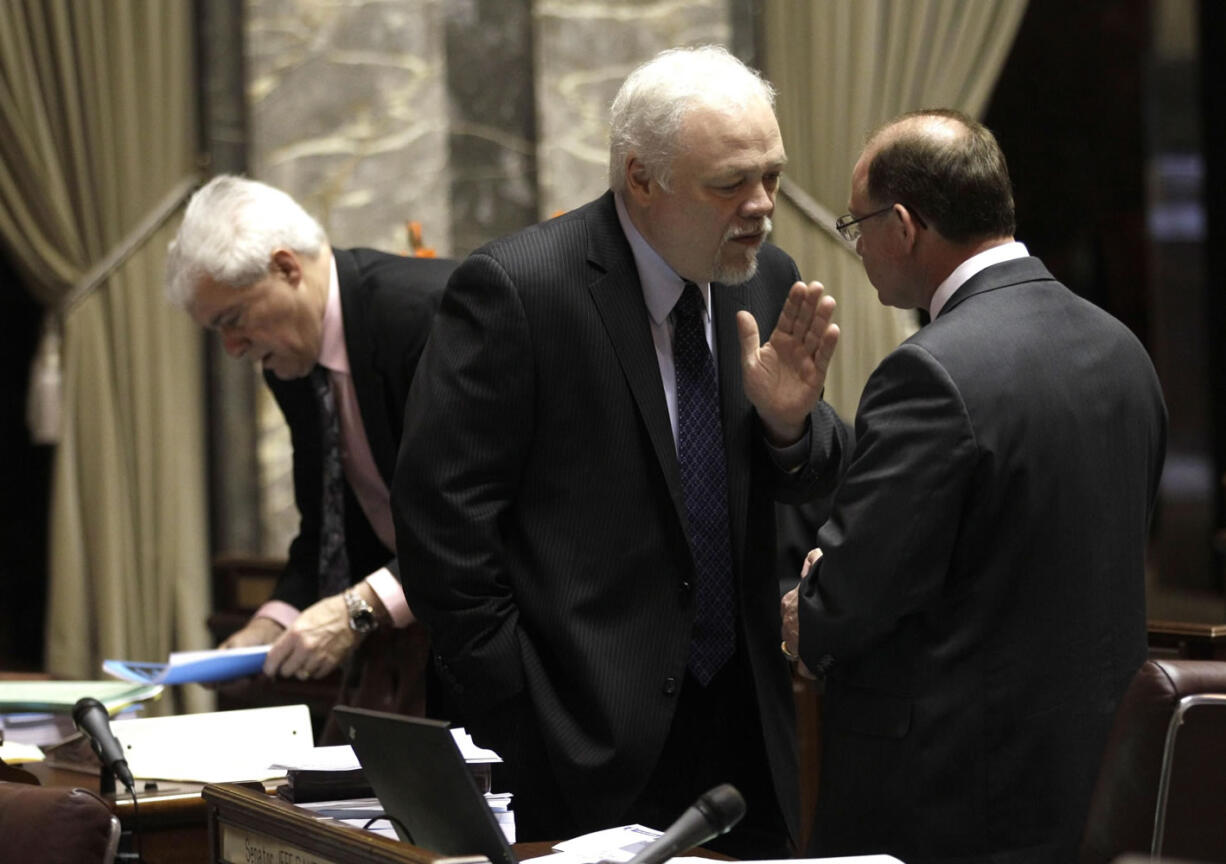 Sen. Don Benton, R-Vancouver, center, talks with Sen. Jeff Baxter, R-Spokane, right, on the Senate floor on April 13. Behind Benton is Sen.