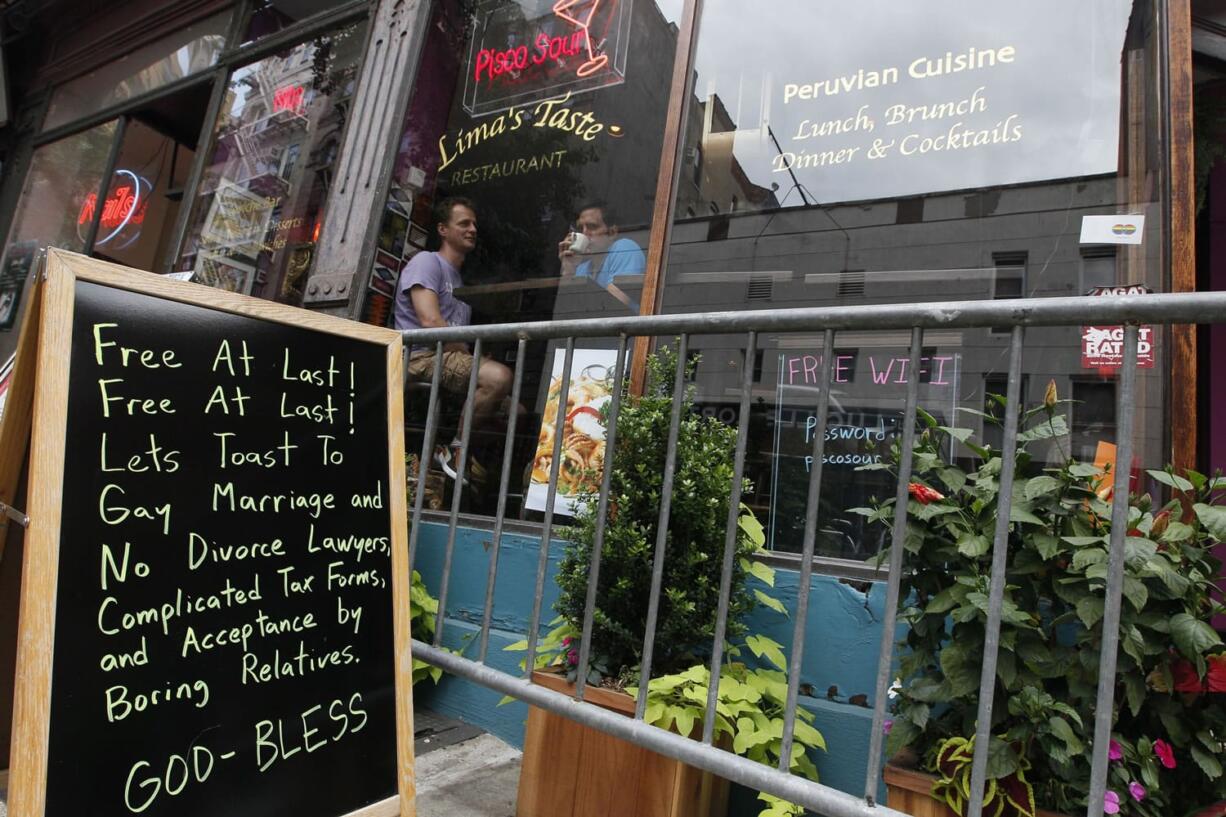 A sign outside a restaurant  in the Greenwich Village neighborhood of Manhattan celebrates the same-sex marriage bill, Saturday, June 25, 2011 in New York. Gov.