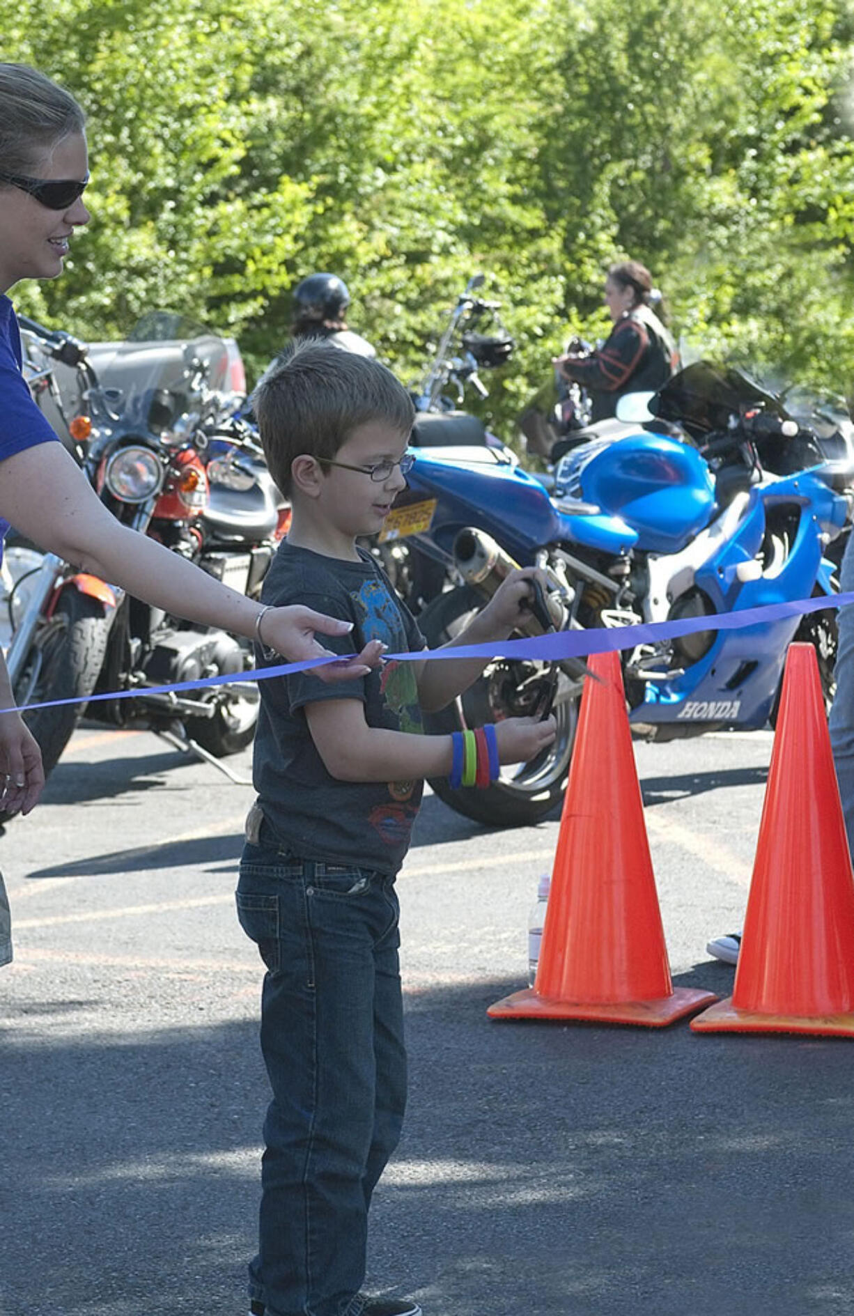 Fisher's Landing: Austin Vellek, son of Sharla and Rolf Vellek, cut the ribbon at the start of the Children's Cancer Association JoyRide.