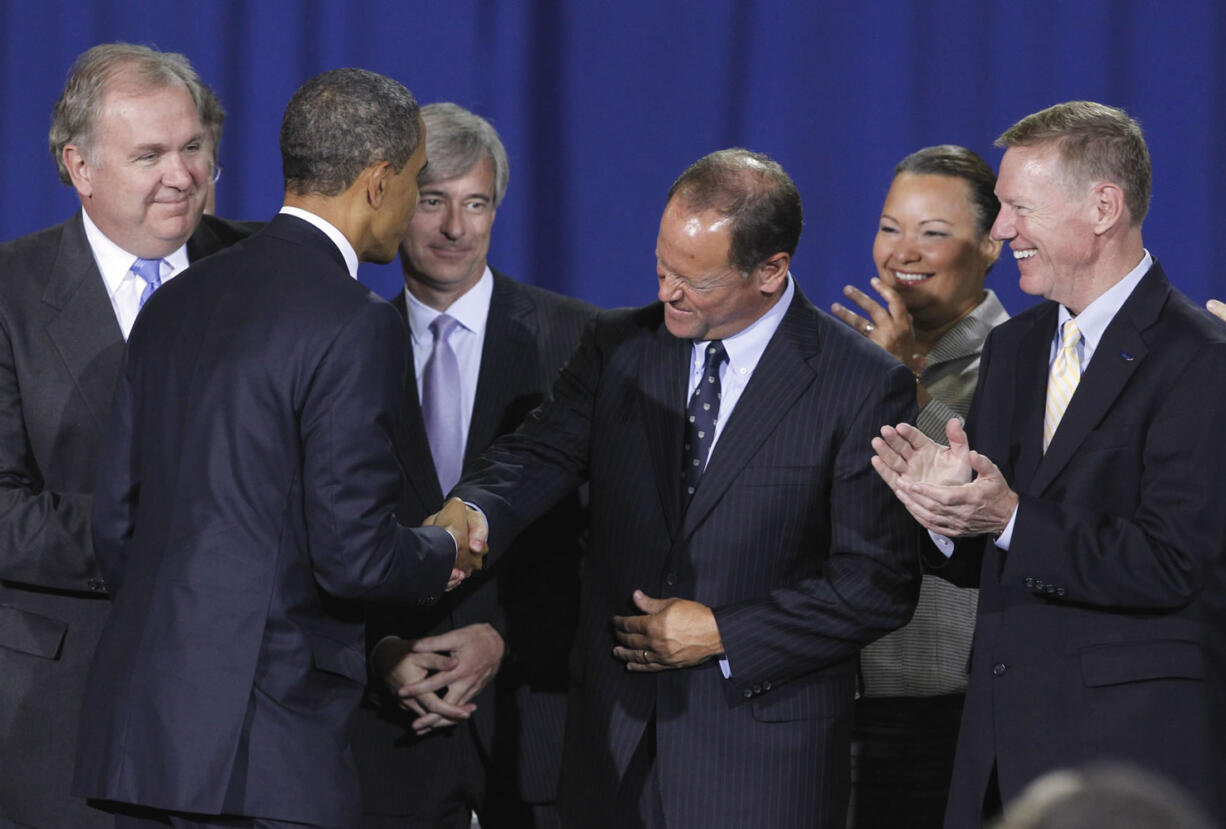 President Barack Obama greets Ford President and CEO of Ford Alan Mulally, center, Friday at the Washington Convention Center in Washington, D.C., where he announced new fuel efficiency standards for cars and light trucks.