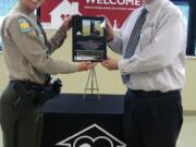 Clark County Sheriff Reserve Association President Debora Wonderly, left, presents a memorial plaque honoring the life of fallen K-9 officer Kane to Humane Society for Southwest Washington Executive Director Chuck Tourtillott earlier this year.