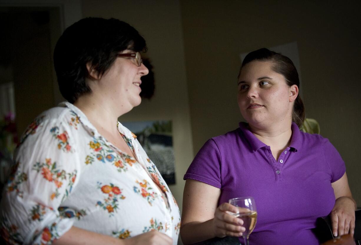 Couple, from left, Morgan Hayes, 27, and Lyndsay Rosenlund, 31, enjoy conversation while preparing dinner in their home on Wednesday.