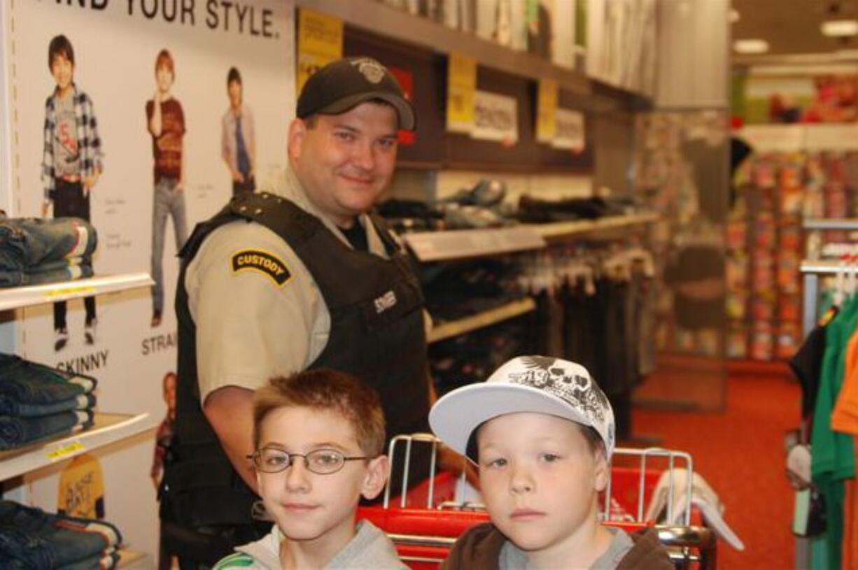 Officer Alva Songer shops for school supplie with Tanner Paul, left, and Taylor Garon-Frazier at the Hazel Dell Target store during a shopping spree given by the Salvation Army.