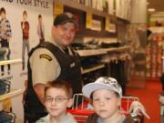 Officer Alva Songer shops for school supplie with Tanner Paul, left, and Taylor Garon-Frazier at the Hazel Dell Target store during a shopping spree given by the Salvation Army.