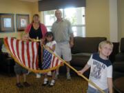 Landover-Sharmel: Vancouver Modern Woodmen of America director Sherree Filla, left, and husband Tim watch as members of the local chapter present a flag to the residents at Bridgewood at Four Seasons Retirement Center.