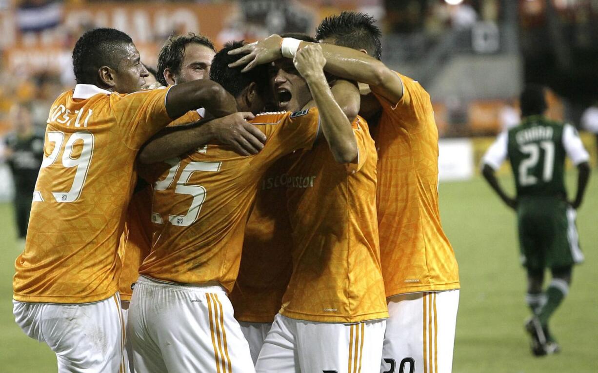 The Houston Dynamo celebrate after Brian Ching (25) scored a goal against the Portland Timbers in the first half Sunday.