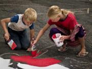 Vancouver Heights: Siblings Oleksiy and Marina Dobryden work together to help paint the Omaha Way street mural.