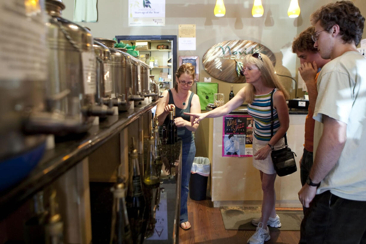 Gabby Navidi helps customer Jane Neville find a vinegar at Navidi's Olive Oils &amp; Vinegars in Camas.