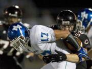 Scott Feather (52) of Camas forces a fumble by Mountain View's Justin Rinta (17) which was recovered and returned 16 yards for a touchdown by Camas' John Norcross during the second quarter at Doc Harris Stadium on Friday.