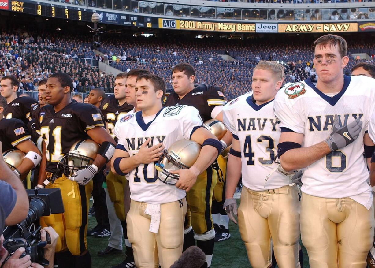 Army's Brent Dial (21), Navy's Ed Malinowski (10), Chris Wade (43) and Chandler Sims (6) stand for their academy's anthems following the 2001 game at Philadelphia.