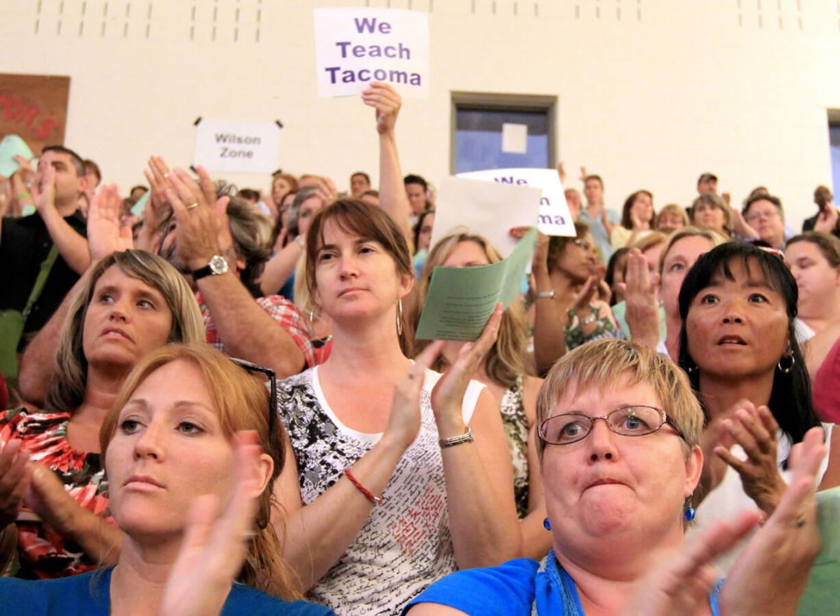 Members of the Tacoma Education Association applaud at the start of a meeting Monday to vote whether to strike at Mount Tahoma High School.