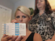 Linzy Hildreth, 25, holds a drug test kit, accompanied her mother Kim Hildreth, at their home-based office in Farmers Branch, Texas.