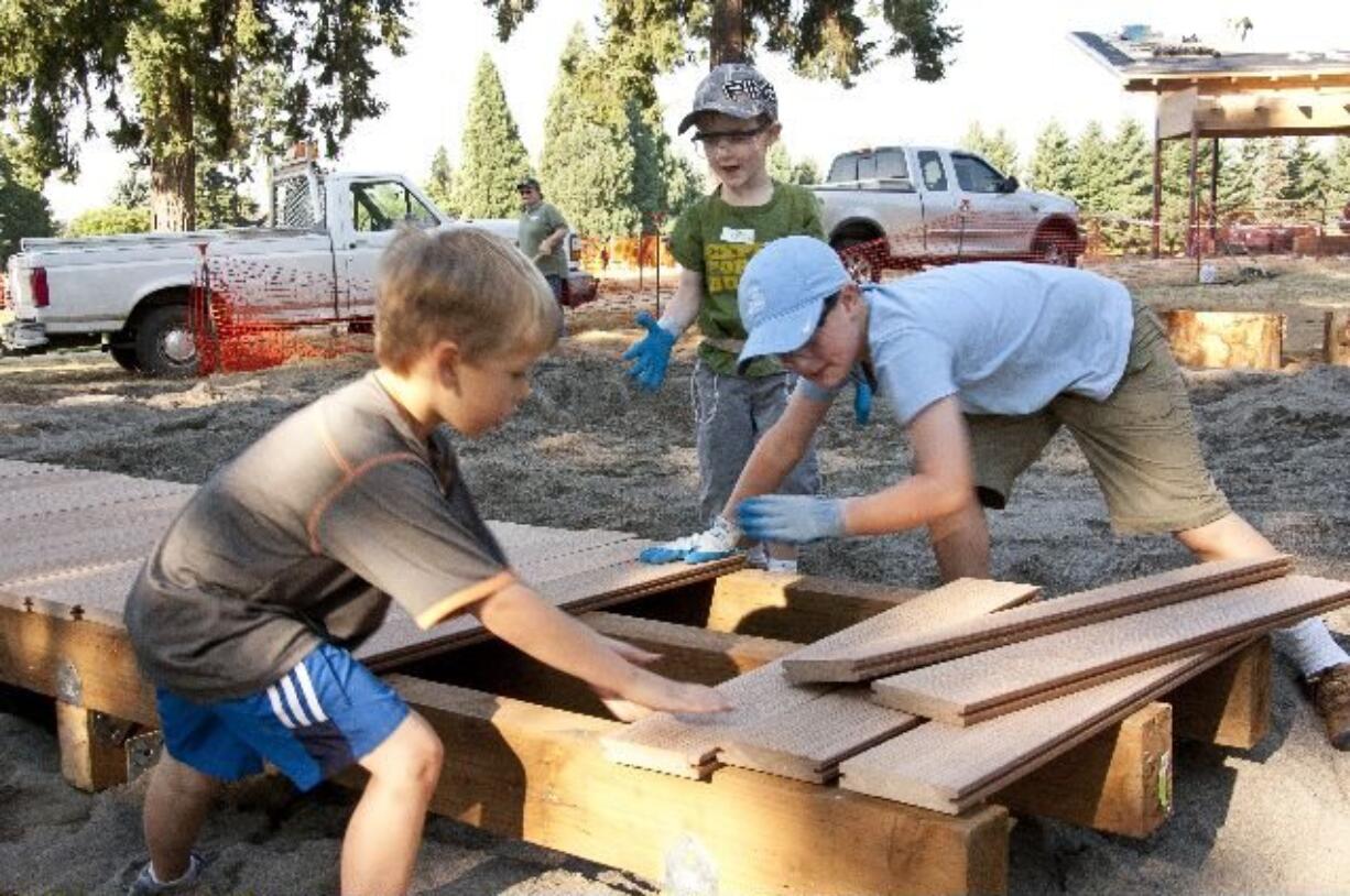 Central Park: Andy Kleiner, from left, Spencer Moody and Graham Moody work on a new walkway for Marshall Community Park.