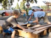 Central Park: Andy Kleiner, from left, Spencer Moody and Graham Moody work on a new walkway for Marshall Community Park.