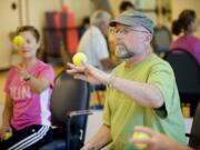 Dan Maxwell uses a tennis ball to improve hand dexterity during a class at the Waterford at Fairway Village Tuesday. Maxwell, who has Parkinson's disease, advocated for exercise classes for people with movement disorders a year and a half ago.