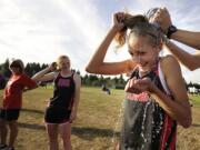 Union freshman Alexis Fuller gets a cold splash of water on her back before running a varsity race at a meet at Skyview High School.