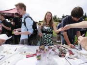 Washington State University Vancouver students Mackenzie Spray, 20, from left, Stephanie Wiese, 19, and Jon Elias, 20, register to vote and sign pledge cards at a voter pledge drive Thursday on the WSUV campus.