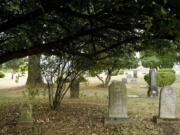 Trees overhang many older markers at Brush Prairie Cemetery, where several early Clark County pioneers are buried.