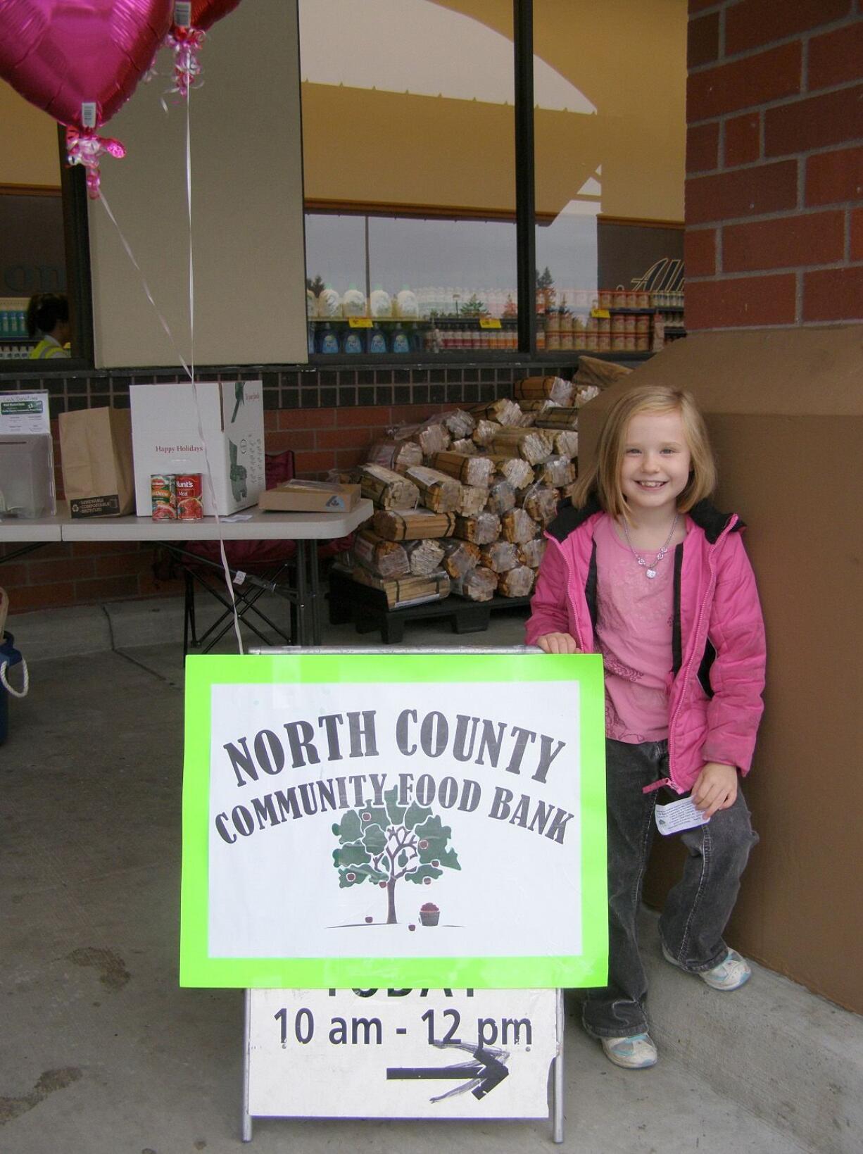 Elizabeth Rowe invites shoppers to donate food to the North County Community Food Bank uutside a Battle Ground grocery store