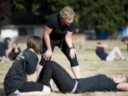 Pfc. Lee Kershaw, center, works with new recruits Ranee Watkins, 23, left, and Renee Costello, 20, during the physical training Thursday. Kershaw volunteers her time once a week to mentor recruits in the Army's Future Soldiers program.