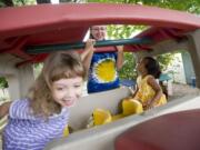 Home child care provider Sandi Lindsey-Tremble goes along for &quot;a ride&quot; Sept. 14 with Ruthie Massey, 4, left, and Keira Limbrick, 3, in Lindsey-Tremble's backyard.