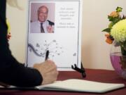 An attendee signs a guest book before Hal Dengerink's memorial service at Washington State University Vancouver on Saturday.