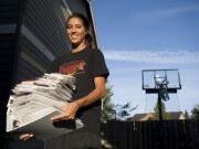 Heather Corral holds a stack of college information from her recruitment process.