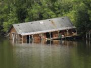 An abandoned houseboat, here in July, was moved off the bank of the Lake River near Ridgefield last year.