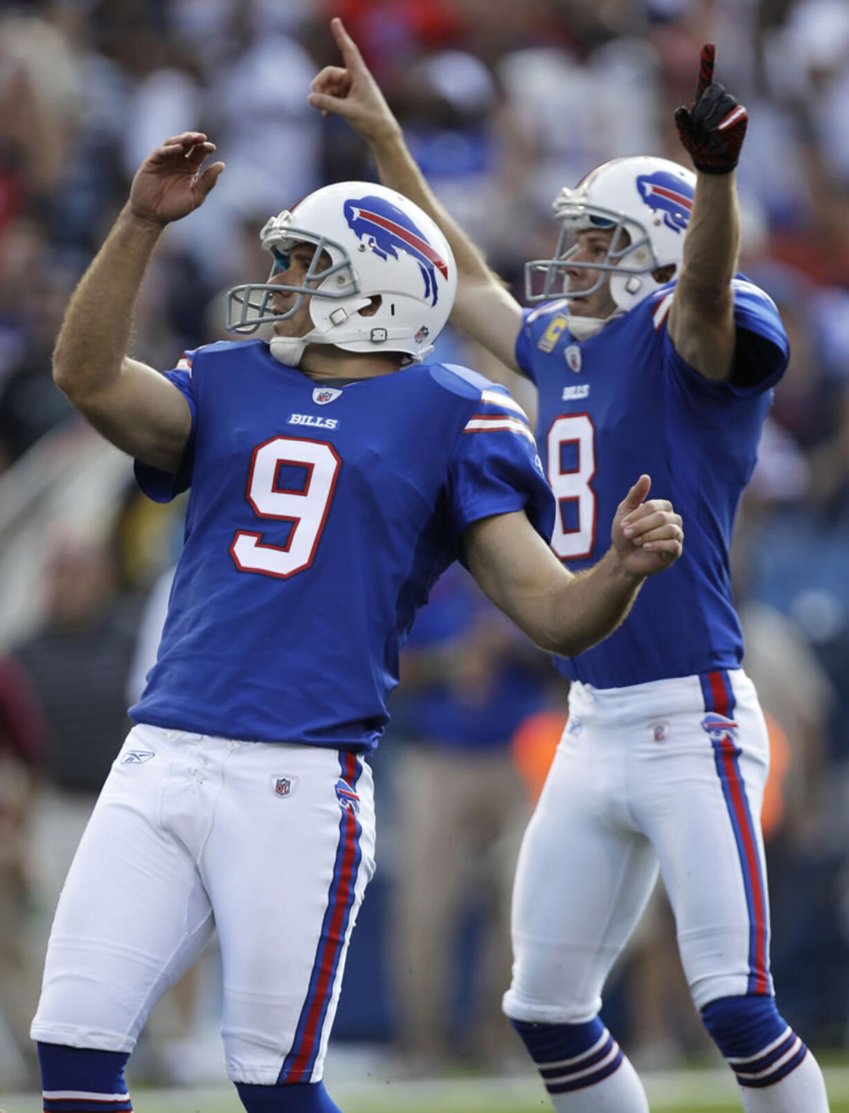 Buffalo Bills' Rian Lindell (9) watched the flight of his game-winning field goal as holder Brian Moorman (8) celebrates.