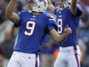 Buffalo Bills' Rian Lindell (9) watched the flight of his game-winning field goal as holder Brian Moorman (8) celebrates.