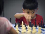 Jason Chang, 7, contemplates his next move while playing Plunder Chess against Alice Tang, 6, at EinsteinWise in east Vancouver.