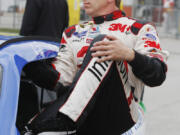 Driver Greg Biffle (16) climbs out of his race car after his qualifying run at Kansas Speedway.