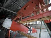 Patrick Garrison, right, fastens the top wing of his replica Fokker Dr.1 triplane Friday at Pearson Air Museum.