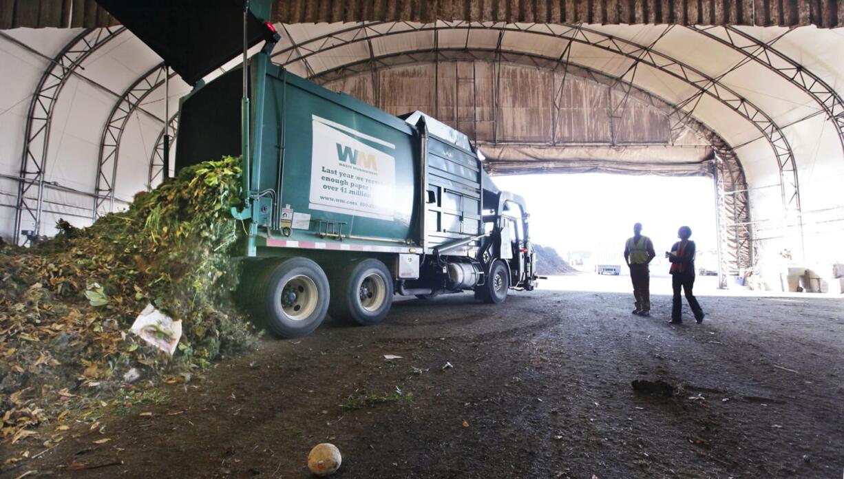 A truck dumps compostable materials in a receiving area at the Cedar Grove processing facility in Everett.