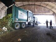 A truck dumps compostable materials in a receiving area at the Cedar Grove processing facility in Everett.