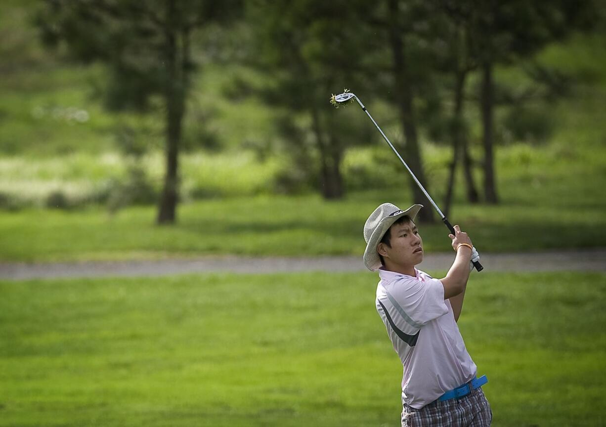 Boon Kusolsomboon of Fort Vancouver hits onto the 18th green during the final round of the 3A district golf tournament at Tri-Mountain.