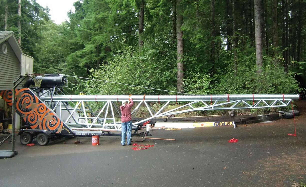 Jeff Peterson fastens the pumpkin cannon's 38-foot barrel to its supporting framework.