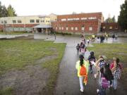 Yuliana Zuazor, 13, a student at Discovery Middle School and a volunteer with Washington Elementary School's Walking School Bus program, walks with students as they complete their quarter-mile trip to the Rose Village school.