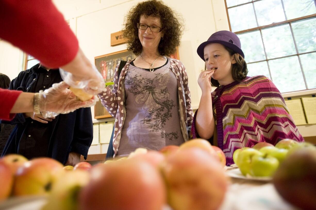 Abby Walden, 9, and her mom, Anne-Marie Walden of Hockinson, sample one of 220 varieties at Apple Fest on Sunday.