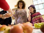 Abby Walden, 9, and her mom, Anne-Marie Walden of Hockinson, sample one of 220 varieties at Apple Fest on Sunday.