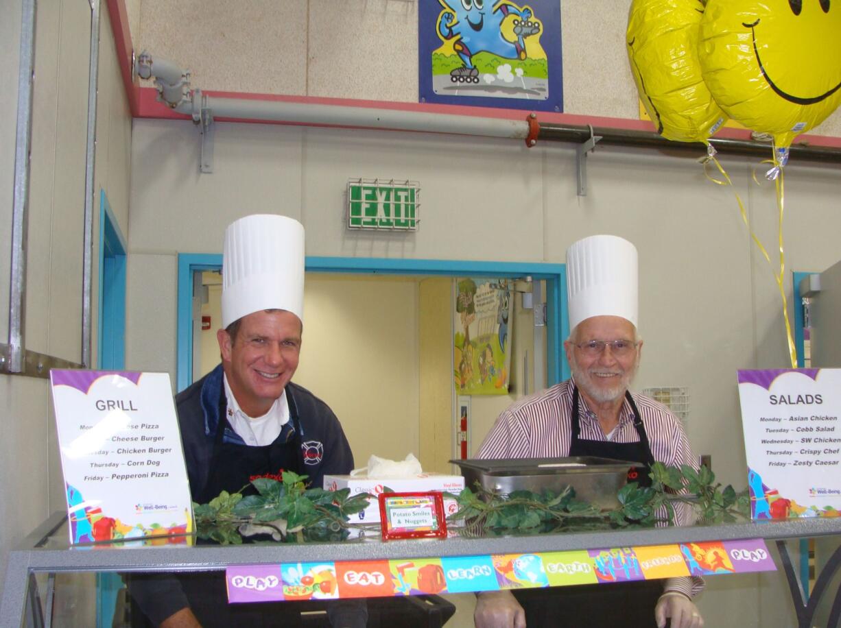 Battle Ground: Battle Ground Mayor Mike Ciraulo, left, and School Board member John Idsinga prepare for a wave of lunch customers at Captain Strong Primary.