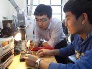 Washington State University Vancouver assistant professor Jie Xu, left, works with grad student Mike Yu.