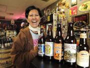 Arlene Nunez, owner of By the Bottle, shows off a selection of fall beers at her store.